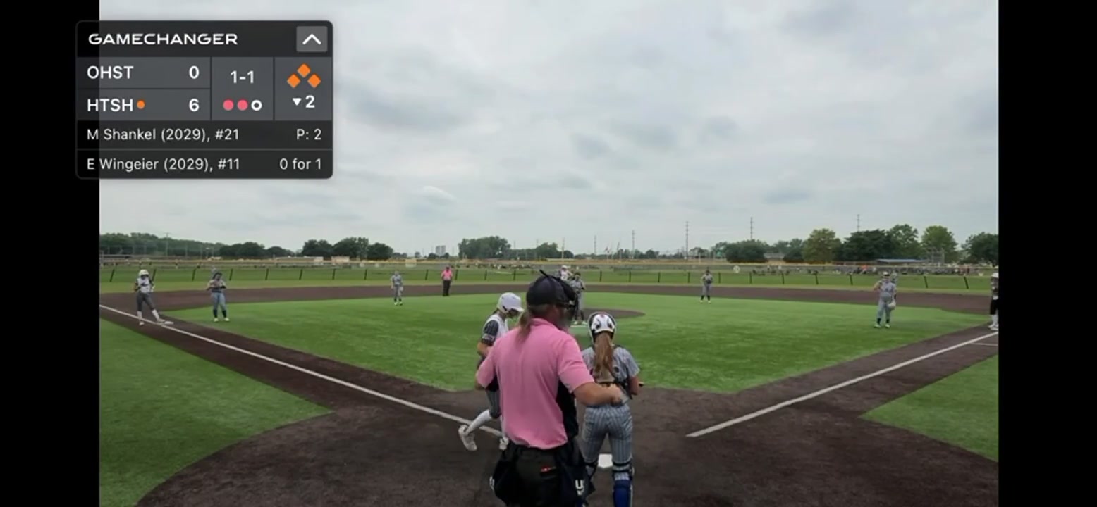 Fastpitch softball game viewed from behind home plate